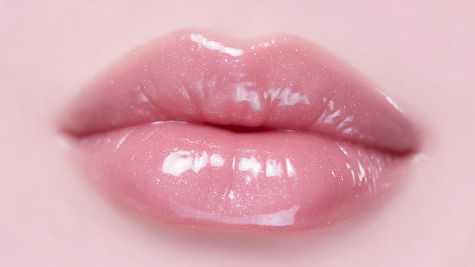 Lábios com gloss de brilho espelhado e reflexo holográfico (imagem ilustrativa)